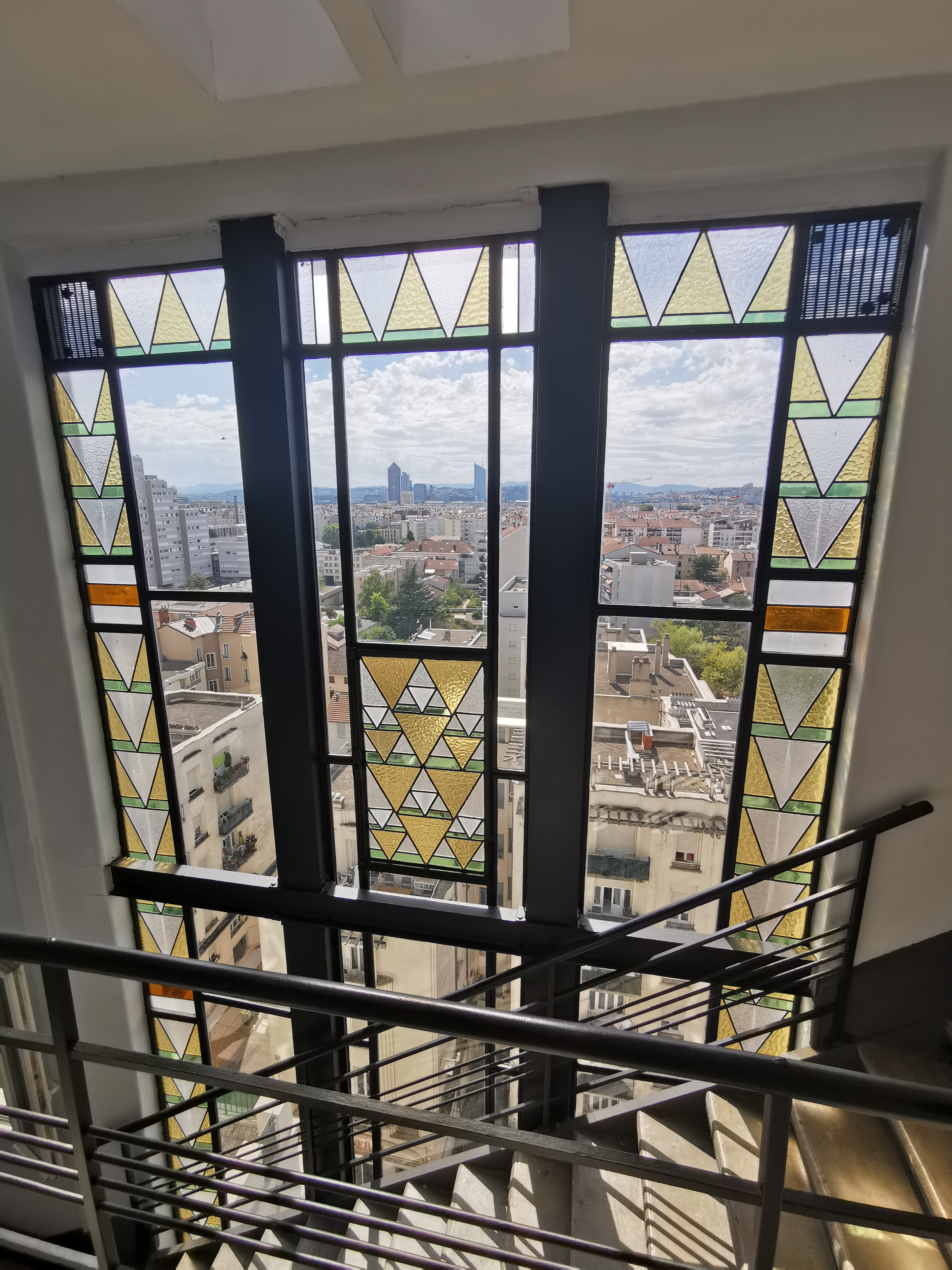 Vue sur Lyon à travers une grande baie vitrée, tour Part-Dieu en arrière-plan